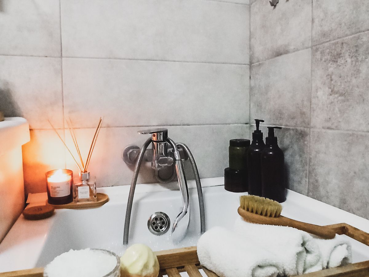 Bougie et essentiels de bain sur un plateau en bois